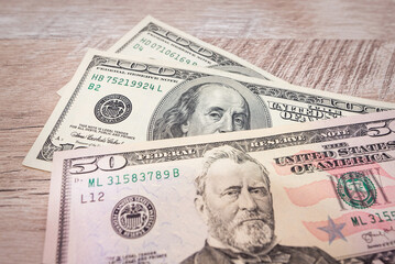 different dollars on a wooden background.