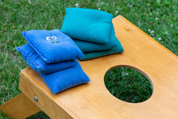 Corn hole or bean bag toss game board and bags with a fun and silly face