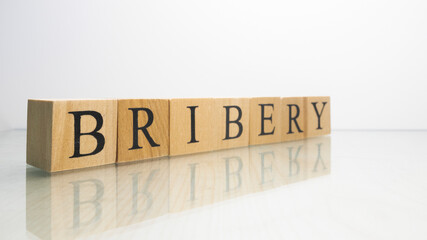 The name Bribery was created from wooden letter cubes. finance and illegal.