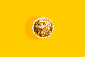 bowl of ramen noodles on yellow surface
