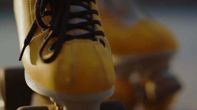 Closeup yellow roller skates with details. Female skater feet in rollerblades.