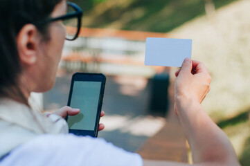 Young woman with headphones making payment using credit card