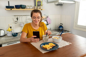 Fototapeta na wymiar Young latin woman eating healthy breakfast with fruits at home.