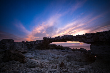 Fototapeta na wymiar Natural arch of Portinatx at sunset, Ibiza, Spain