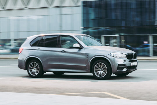 BMW X5 Third generation F15, car driving in city with motion blur, view from the side