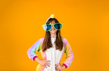 a cheerful girl in a plush suit and funny glasses stands on a yellow background with a place for...