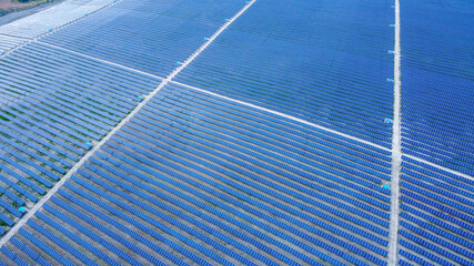 Background of solar panels array as seen from above the modern static solar power station. Green...