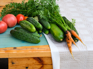 Fresh organic tomatoes, cucumbers, zucchini and carrots on wooden table