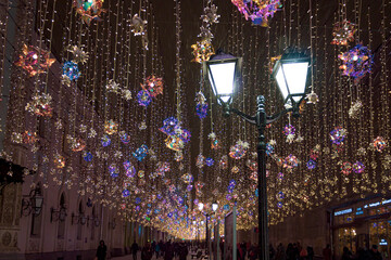 Street lamp and beautiful decorations during snowfall