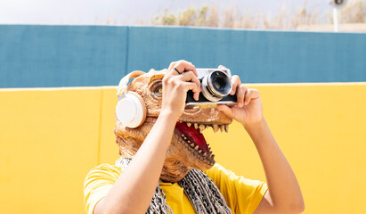 woman with t-rex mask has a photo camera, in the city