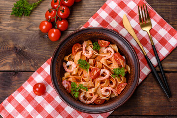 Fettuccine pasta with shrimp, cherry tomatoes, sauce, spices and herbs