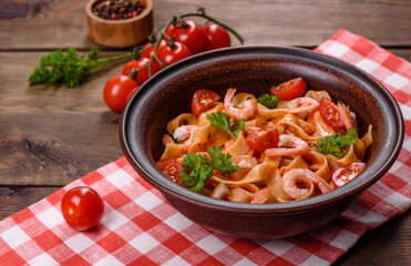 Fettuccine pasta with shrimp, cherry tomatoes, sauce, spices and herbs