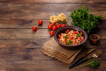 Fettuccine pasta with shrimp, cherry tomatoes, sauce, spices and herbs