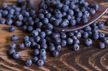 Blueberries are scattered on a wooden surface. Superfood berries are good for health.