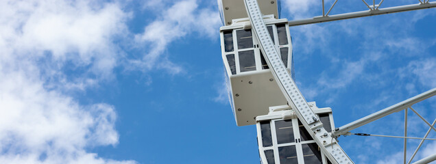 close up ferris wheel cabins with blue sky background