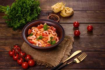 Fettuccine pasta with shrimp, cherry tomatoes, sauce, spices and herbs