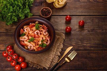 Fettuccine pasta with shrimp, cherry tomatoes, sauce, spices and herbs