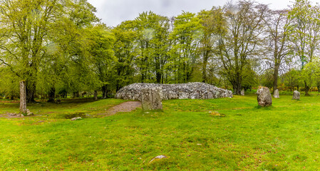 Naklejka premium A view of standing stones and ancient burial tombs at Clava Cairns outside Inverness, Scotland on a summers day