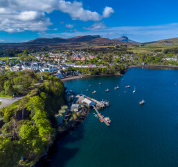 Fototapeta na wymiar A panorama aerial view along the coast and the town of Portree on the Isle of Skye, Scotland on a summers day