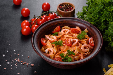 Fettuccine pasta with shrimp, cherry tomatoes, sauce, spices and herbs