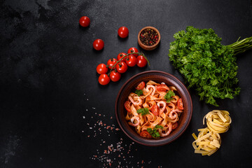 Fettuccine pasta with shrimp, cherry tomatoes, sauce, spices and herbs