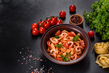 Fettuccine pasta with shrimp, cherry tomatoes, sauce, spices and herbs