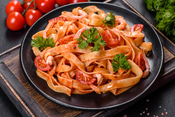 Fettuccine pasta with shrimp, cherry tomatoes, sauce, spices and herbs