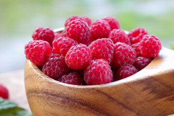 Wooden cup with wild raspberries