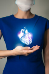 Unrecognizable woman in blue clothes holding highlighted handrawn Heart in hands. Medical...