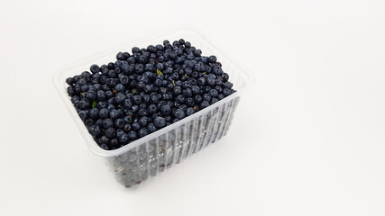 blueberries in a plastic black box insulated on white. sale of summer berries.