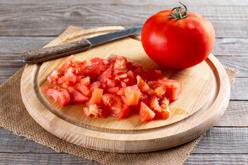 Sliced tomato on a cutting board for making lentil soup. Step by step.