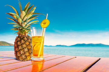 Fruit juices made from pineapples and lemons are placed on the beach.