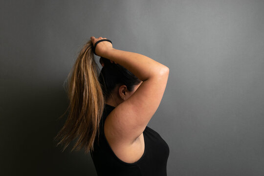 photo of latin woman combing a ponytail in her hair