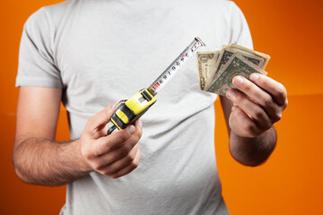 man holding a measuring tape and money