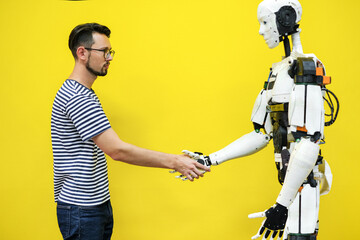 Fototapeta na wymiar a man shakes hands with a robot. engineer to create a robot. robotics future concept