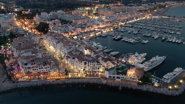 Aerial drone helicopter panoramic view of Puerto Banus Marbella marina luxury port in Spain at dusk