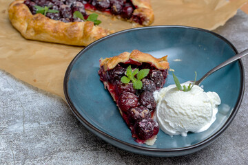 Summer galette with cherries on brown concrete background