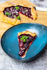 Summer galette with cherries on brown concrete background