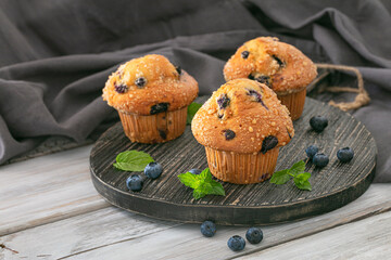 delicious muffins with blueberries on a wooden table. fresh berries and sweet pastries on the board. 