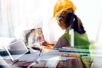 Two colleagues discussing data working and tablet, laptop with on on architectural project at construction site at desk in office