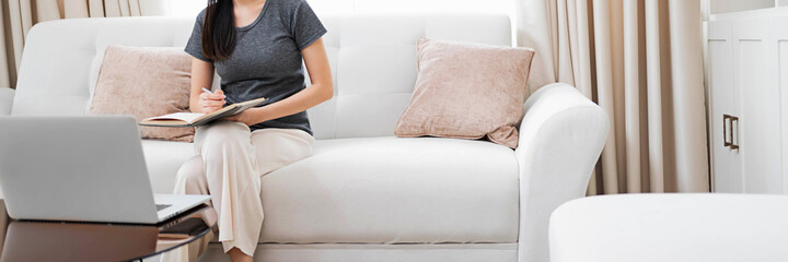 happy Young asian woman  working with laptop in bed at home in the morning.