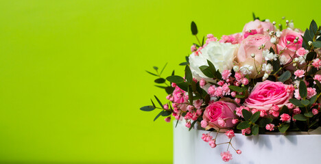 Beautiful pink flowers on a green background in a cardboard box