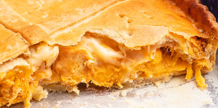 Torta de frango com requeij&atilde;o sendo servida na assadeira de alum&iacute;nio em fotografia macro. Comida Brasileira. Torta tradicional no Brasil servida em lanches e festas.