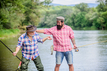 Getting You in Motion. Fly Fishing Time. hobby. Big game fishing. friendship. Camping on the shore of lake. two happy fisherman with fishing rod and net. hunting tourism. father and son fishing