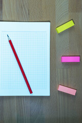 top view of stationery, notebook, pencils and scissors on light wooden surface