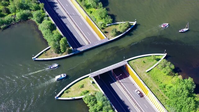 Aquaduct Veluwemeer, Nederland. Aerial view from the drone. A sailboat sails through the aqueduct on the lake above the highway. High quality 4k footage
