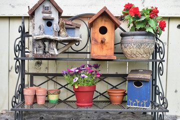 Backyard artistic arrangement of wooden painted birdhouses on garden potting bench, outdoor lifestyle gardening with rustic decor