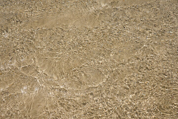Surface of clear water on tropical sandy beach in Crete Greece.