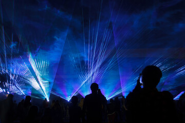 blue laser lights and people silhouettes at concert