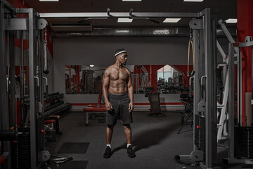 Fototapeta na wymiar African american athletic guy with naked muscular torso standing in gym on training. Sport lifestyle, exercising concept